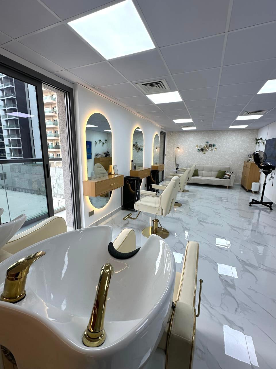 Elegant interior of Bellavue Beauty Salon with modern decor, olive green accents, and golden lighting